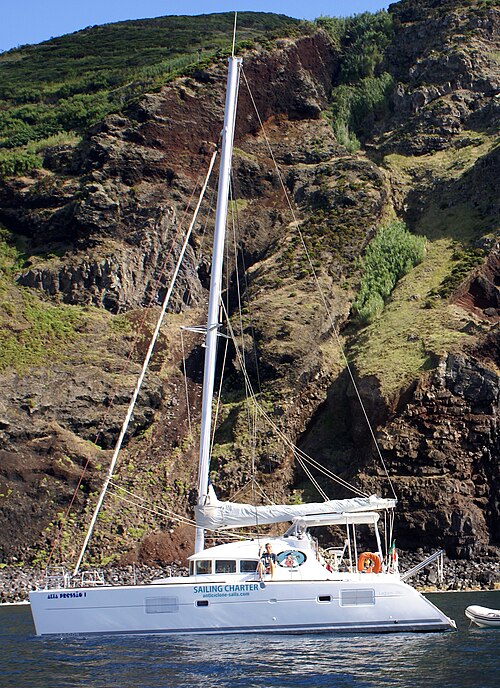 Un catamarán Lagoon 380 fondeado junto a un acantilado